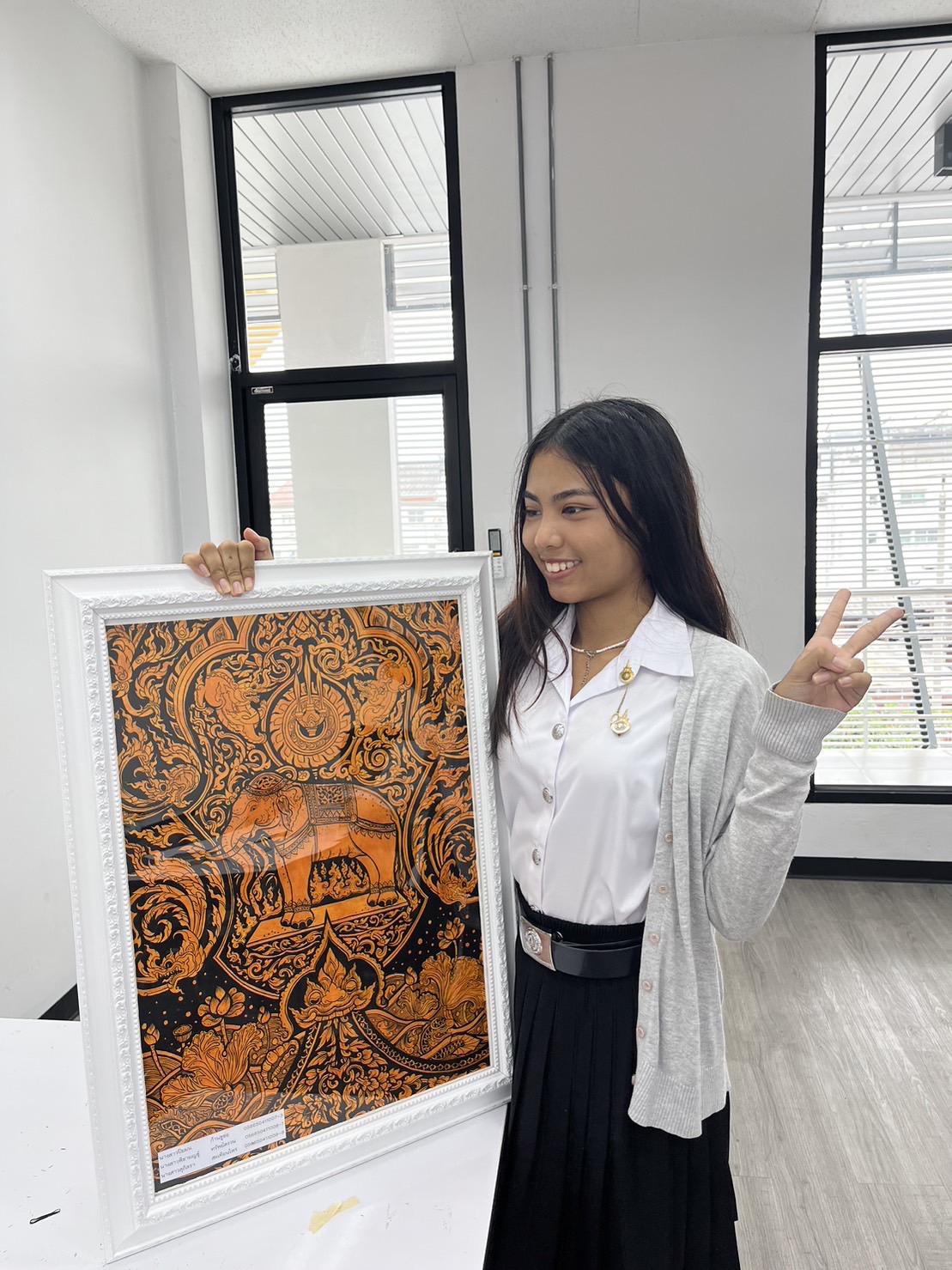Pichamon holding a decorative artwork